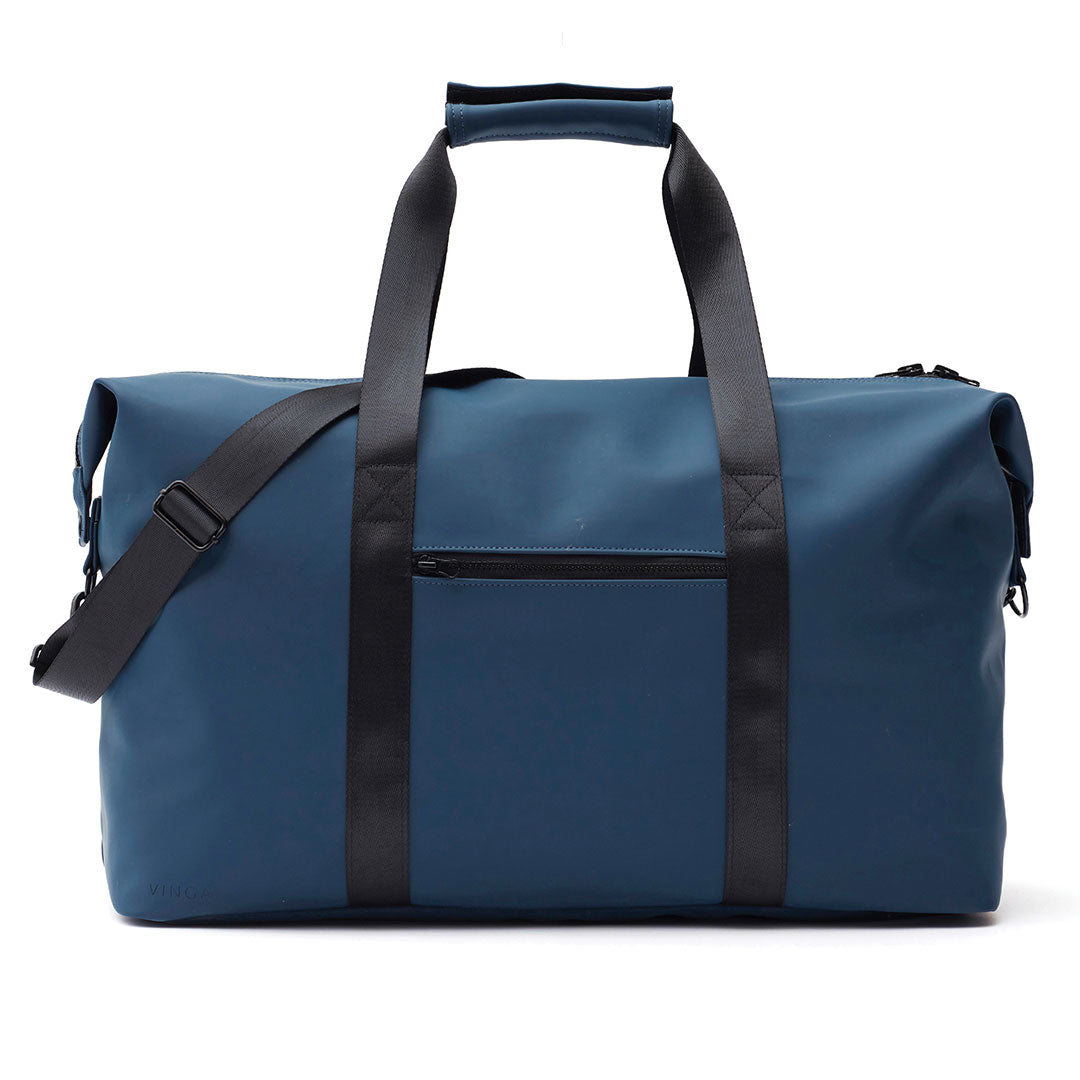 A blue duffel bag with black handles, a black shoulder strap, and a front zippered pocket, photographed on a clean white background.