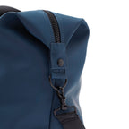 Close-up of a blue backpack with a strap and zipper detail on a white background